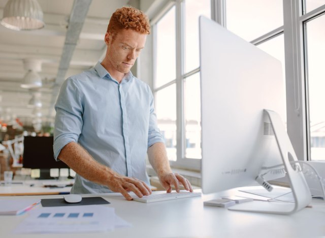 man working at standing desk