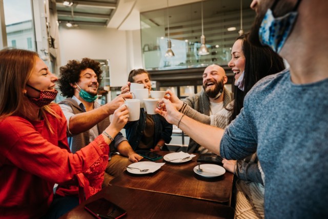 people with face mask drinking at coffee house