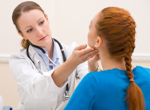 woman getting thyroid exam