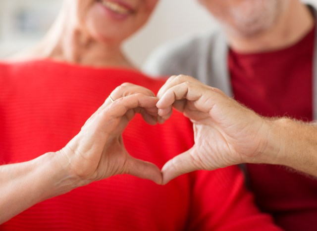 older man and woman holding hands in shape of heart for good heart health