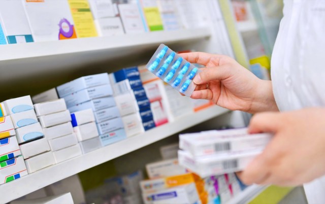 stunning weight loss methods that completely work, say specialists 29 pharmacist holding medicine box and capsule pack in pharmacy drugstore.