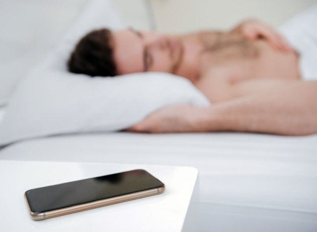 man sleeping phone bedside