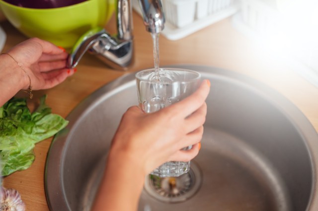 woman hand's filling the glass of water.