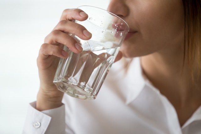 dehydrated woman feeling thirsty holding glass drinking filtered pure mineral fresh water for body refreshment or energy recovery, dehydration problem, hydration