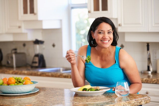 woman eating healthy meal in kitchen