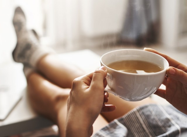 woman drinking tea relaxing on sofa