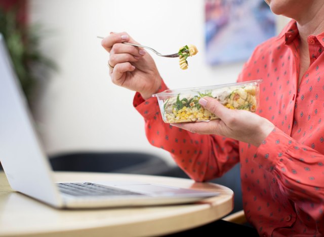 25 harmful habits that are behind you getting fat 136 woman eating lunch at desk