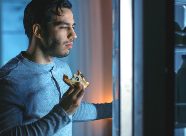 25 harmful habits that are behind you getting fat 144 man eating leftover pizza as a late night snack