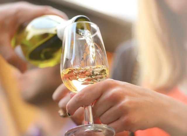 woman pouring glass of white wine