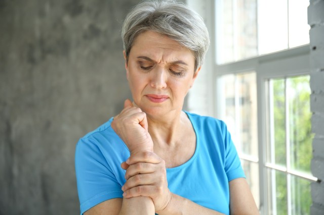 mature woman suffering from wrist pain at home