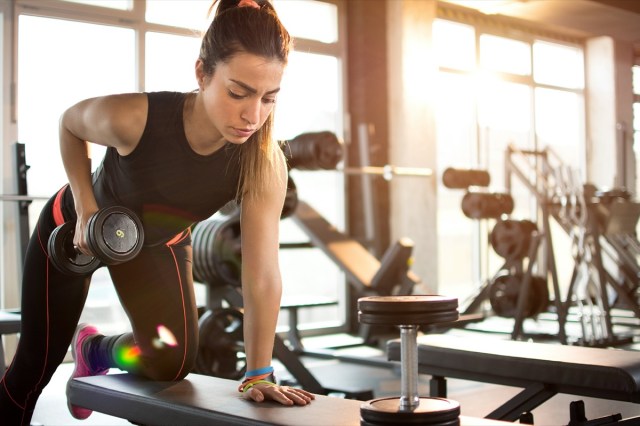 fitness girl lifting dumbbell in the morning.