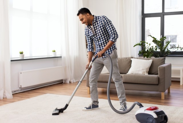 man with vacuum cleaner at home