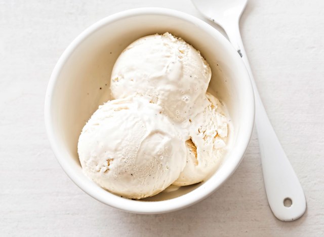 vanilla bean ice cream in white bowl with spoon