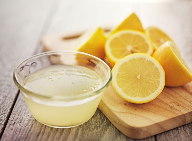 lemon juice in bowl next to sliced ​​lemons