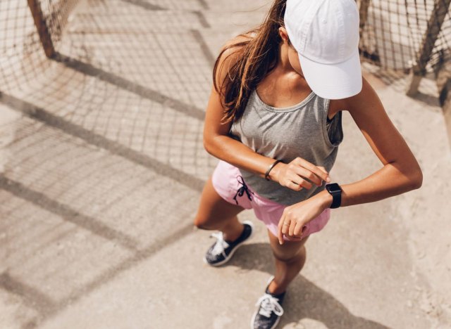 woman looking at fitness watch on a run