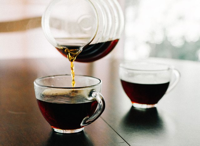 cup of pour over coffee being poured into a mug in the morning.