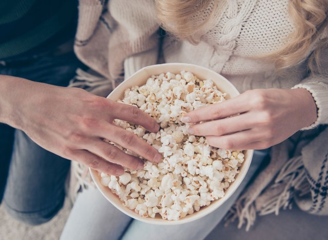 man and woman eating popcorn