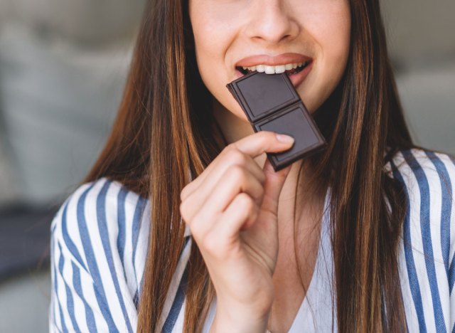 woman eating bite of chocolate bar