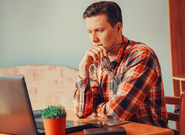 man thinking at a computer