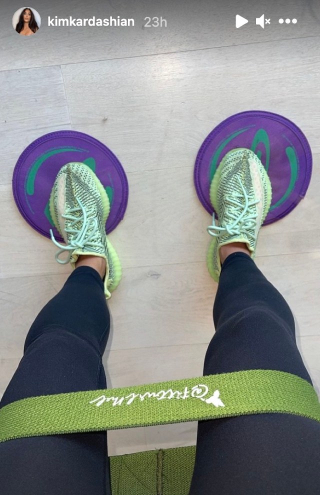 kim kardashian in black leggings standing on purple floor dots in green sneakers