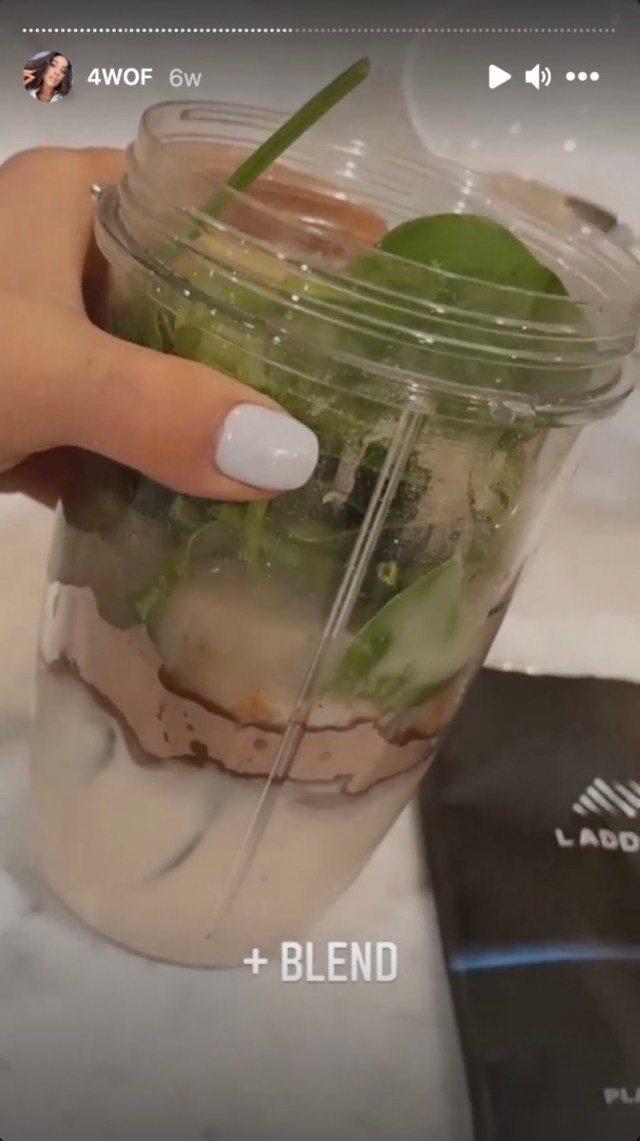 shay mitchell holds a smoothie in a blender cup