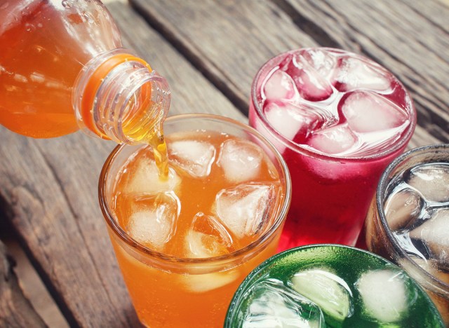 colorful soft drinks are poured into four glasses