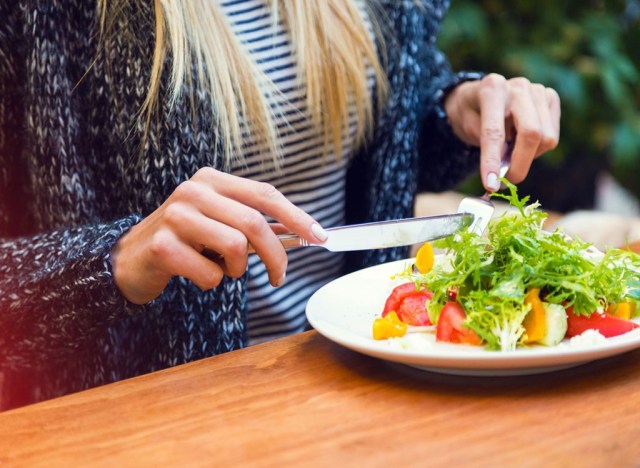 40 weight loss tips that help you drop more pounds 164 woman sitting down eating at a table