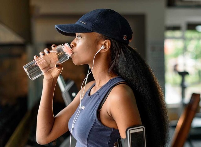 woman drinking water at gym