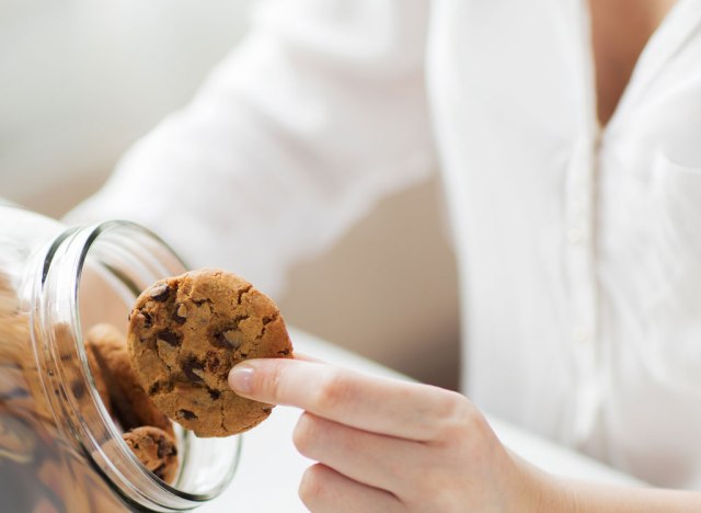 woman grabbing cookie from jar