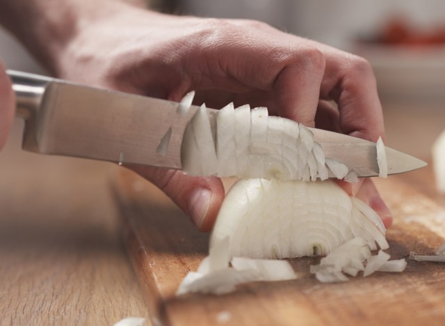 person-chopping-onion-on-cutting-board