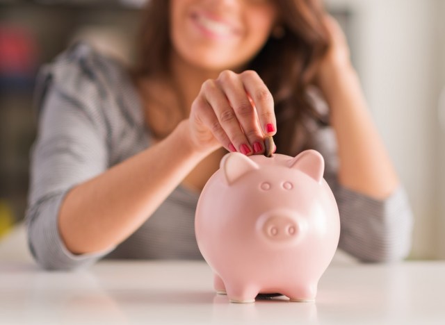 woman putting money in the piggy bank