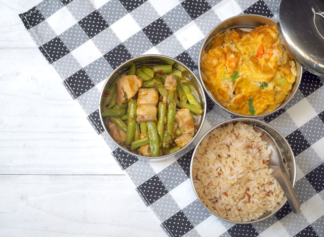 rice meat veggies in antique stainless steel food tins on checkered picnic blanket