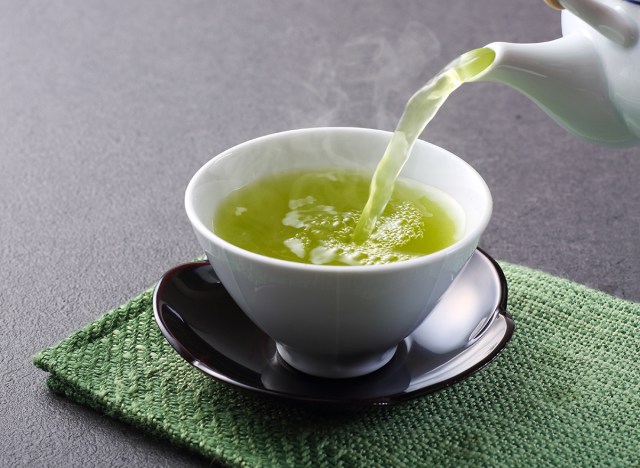 green tea being poured into white teacup