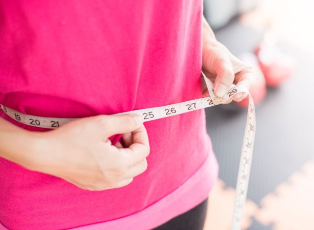 woman measuring her waist