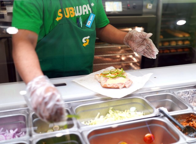 subway sandwich artist making sub