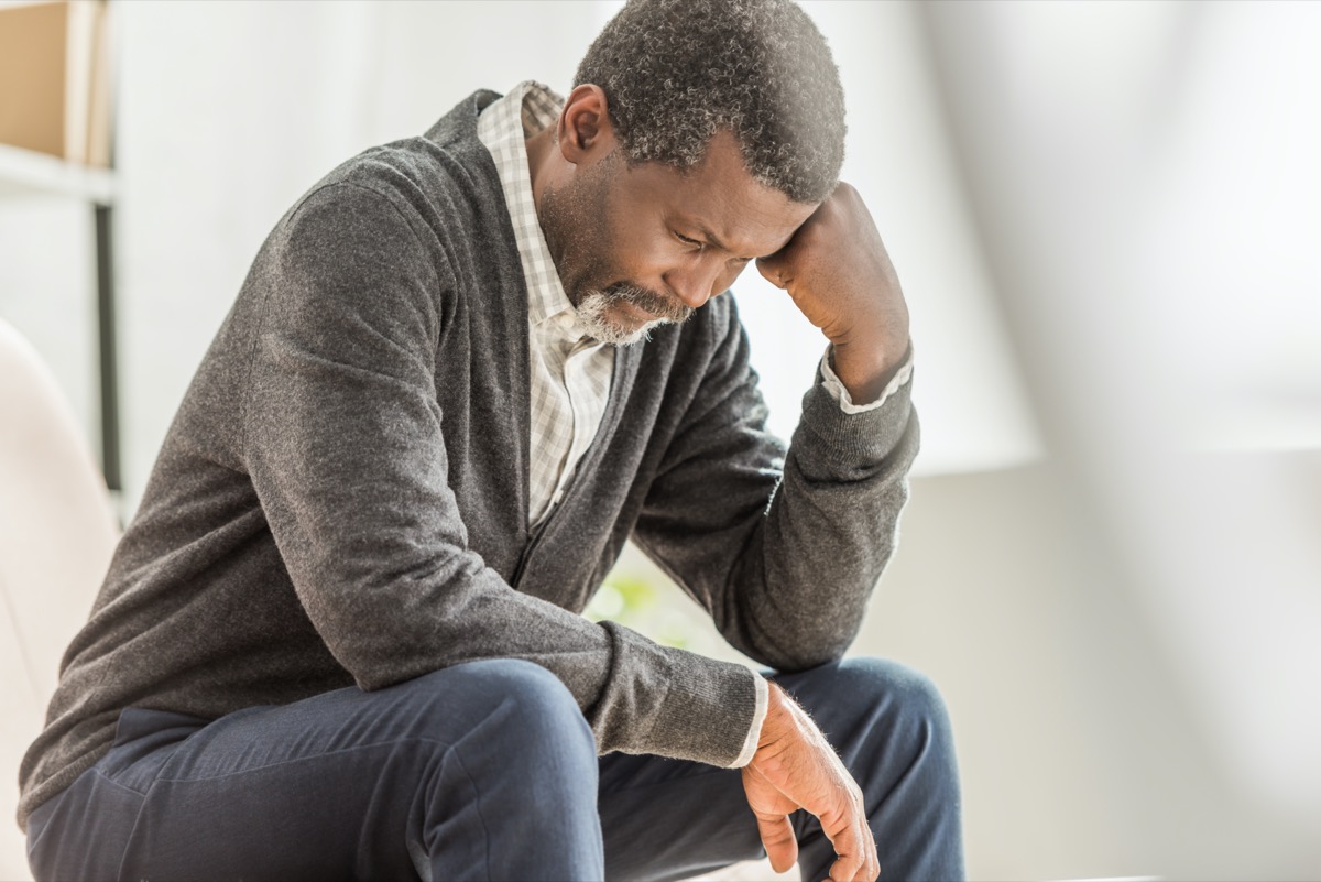 depressed african american man selective focus sitting with bowed head