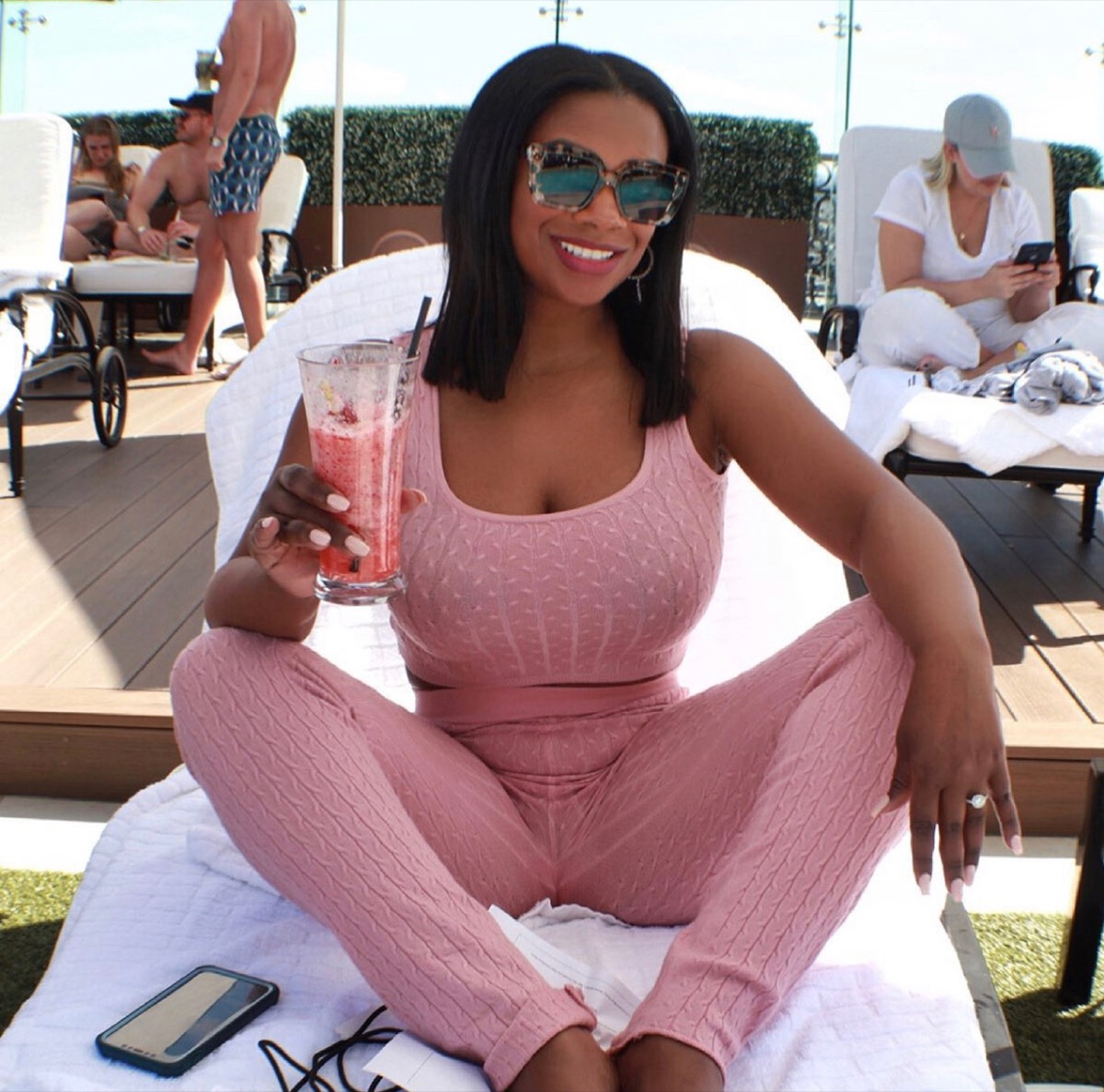 kandi burruss sitting outside drinking pink smoothie in a solid pink outfit