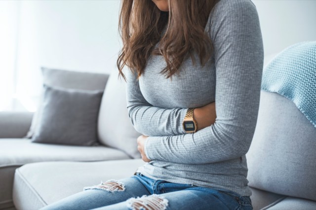 woman lying on sofa looking sick in the living room