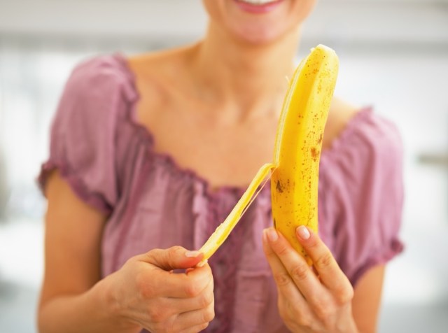 woman in pink shirt peeling banana