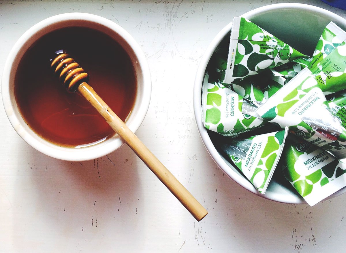 honey in bowl next to bowl of sugar packets