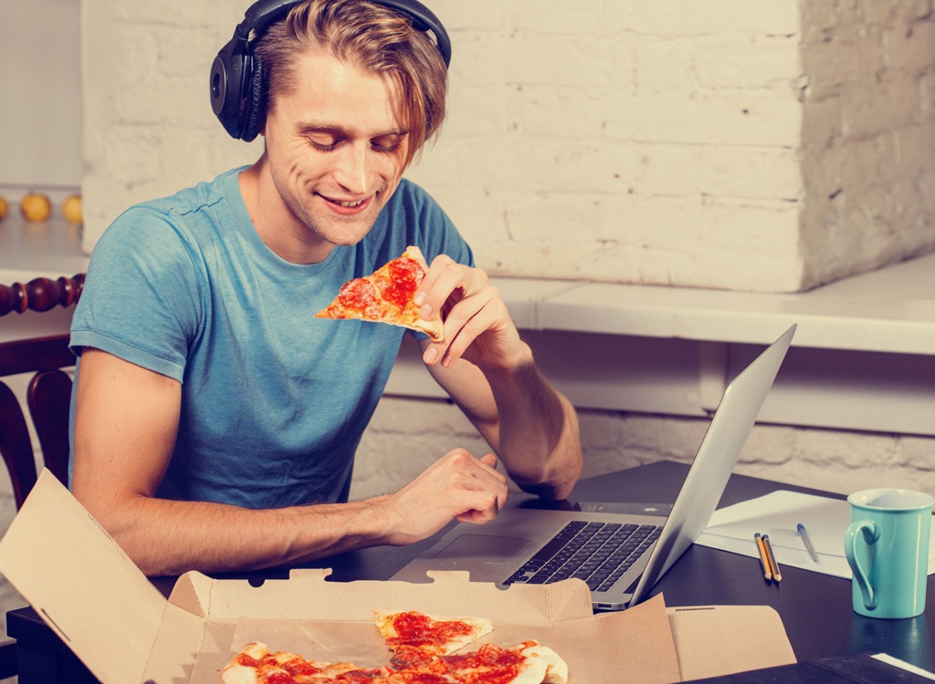 eating pizza headphones laptop