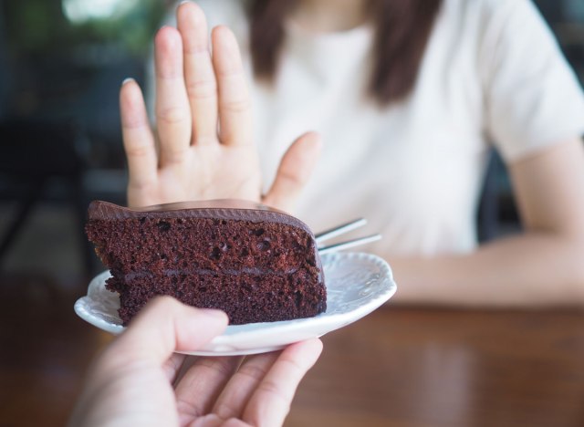 woman saying no to chocolate cake dessert