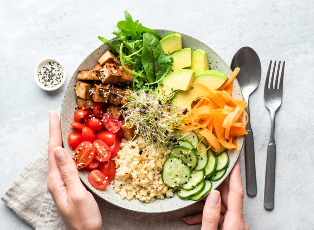 healthy vegetable plant based bowl tomatoes carrots avocado brown rice cucumbers leafy greens