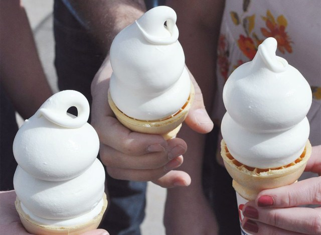hands holding three soft serve ice cream cones dairy queen