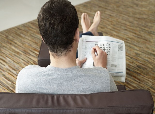 man working on crossword puzzle