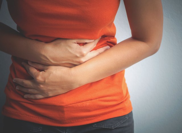 woman holding stomach cramps digestive problems