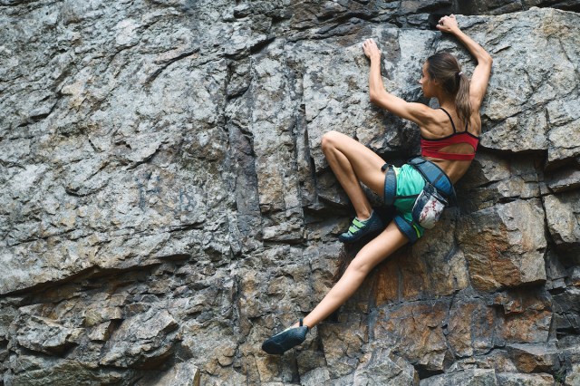sport woman with slim fit body climbing on the mountain having exercise in mountains.  rock climbing hard movements, seeking direction, supremacy