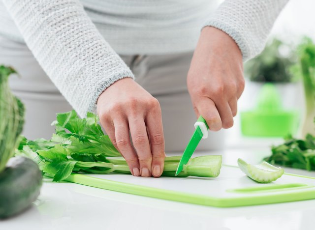person cutting celery with plastic knife