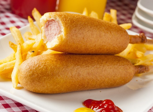 corn dogs and french fries on a white plate
