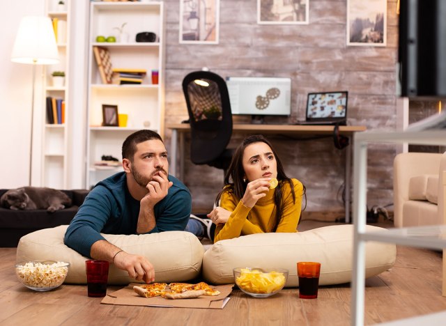 couple watching tv snacking